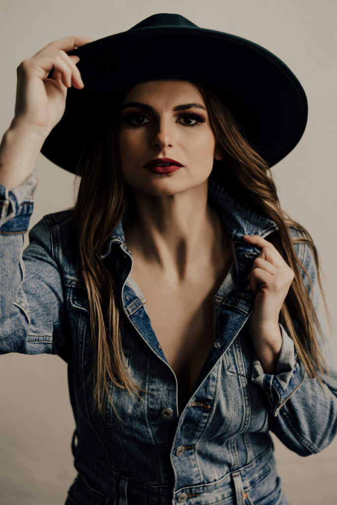 Boudoir Photographer, Woman in jean jacket holds her hat
