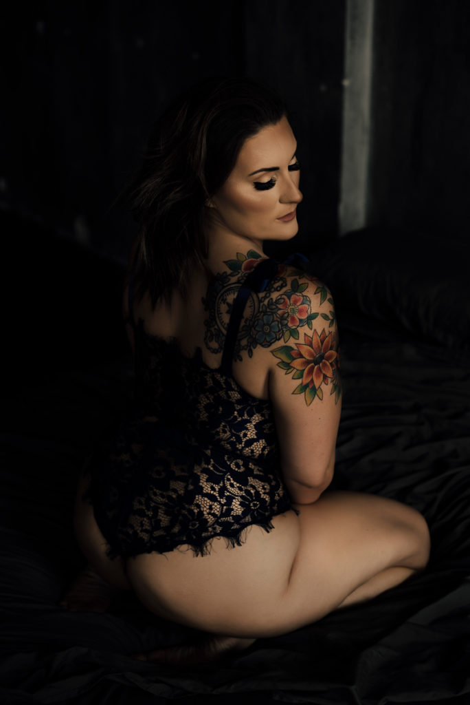 Boudoir Photographer, woman with tattoos sits in lingerie